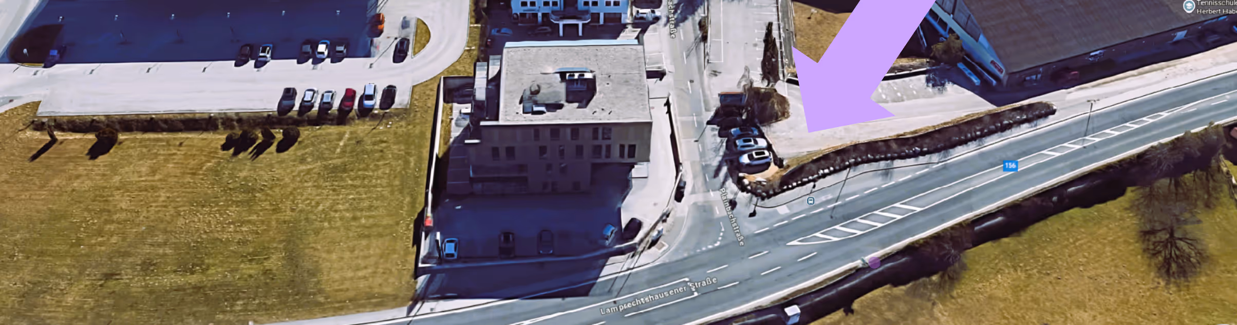 Luftaufnahme eines Geb&auml;udes an der Lampechtshausener Stra&szlig;e mit Parkpl&auml;tzen und umliegenden Gr&uuml;nfl&auml;chen, violetter Pfeil zeigt auf einen Parkplatz.